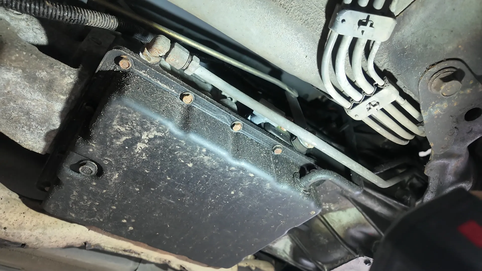 The automatic gearbox from underneath, showing the sump pan and cooler lines