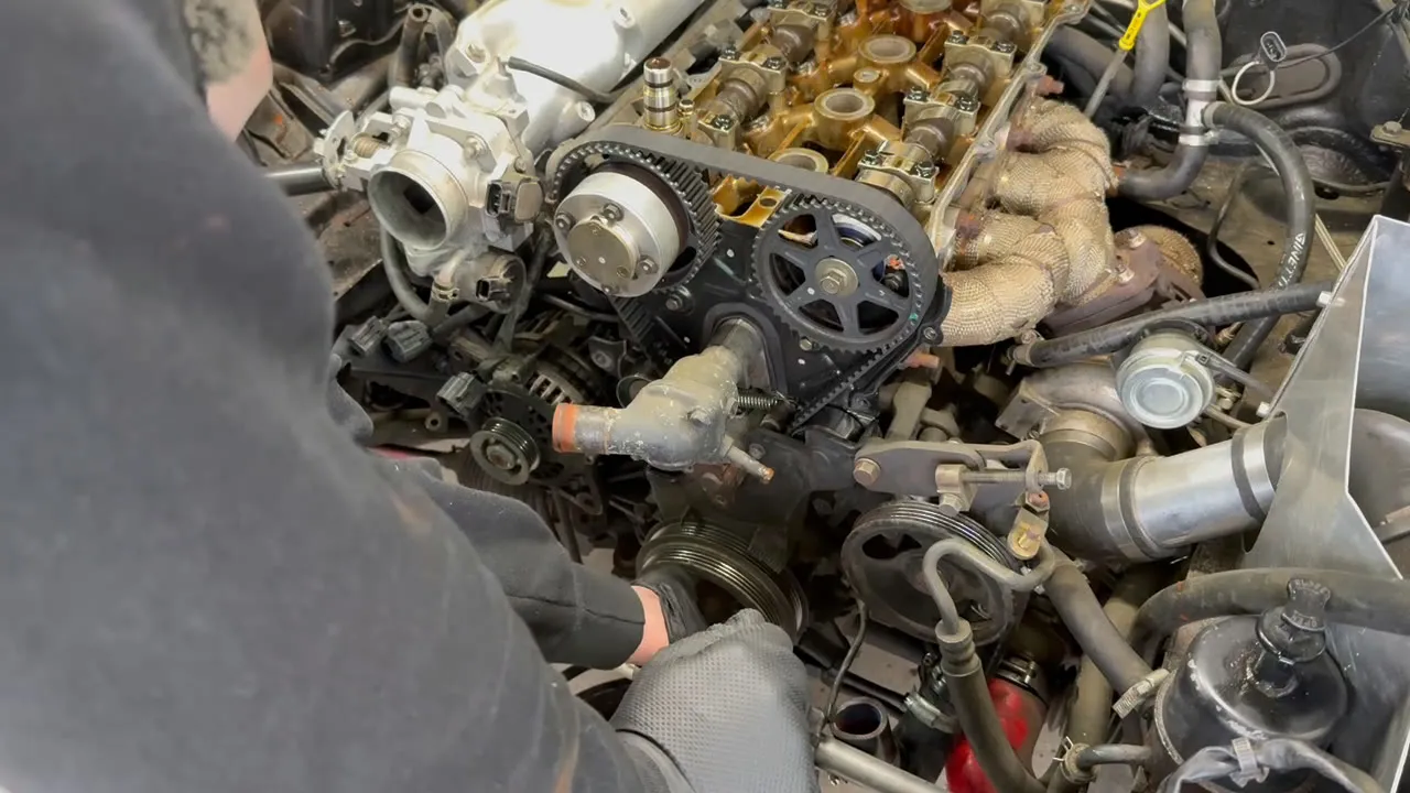 The cam sprockets and old timing belt exposed with the covers removed