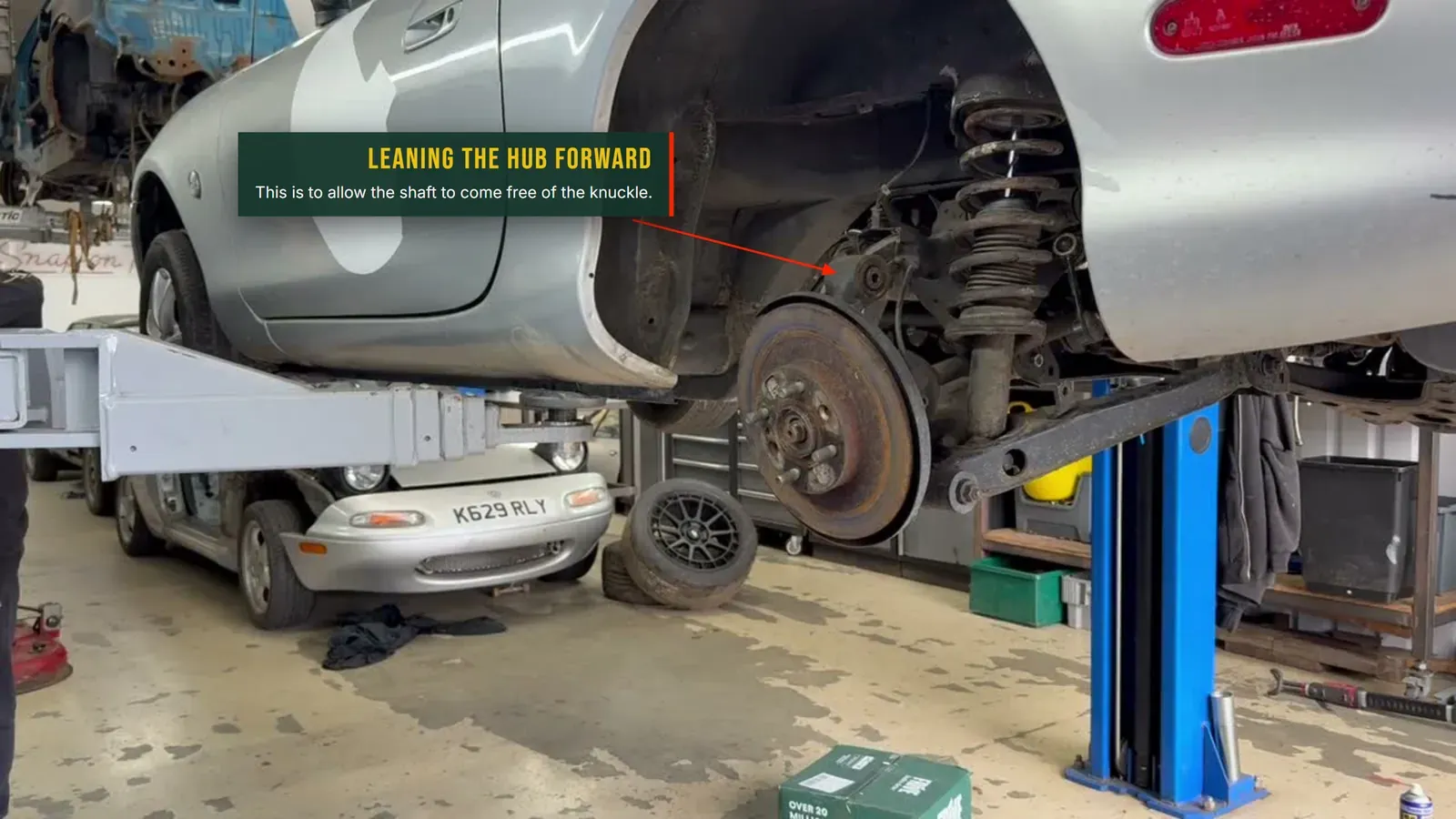 Annotated photo of the hub knuckle leaned forward to free the driveshaft from the knuckle