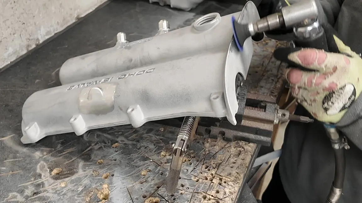 Dressing the welds back on the cover with a die grinder at the bench