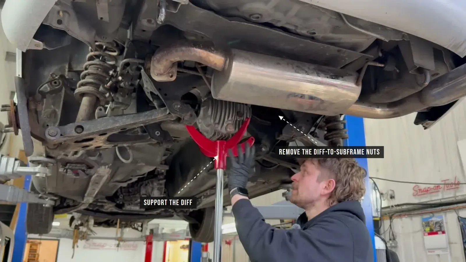 Annotated photo of the differential supported on a jack with the diff-to-subframe nuts called out
