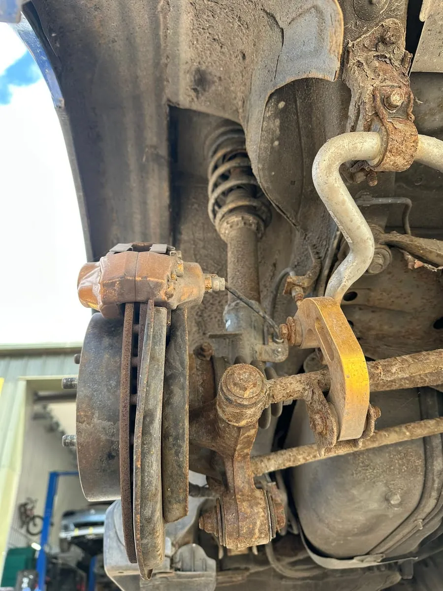 Rusted-through subframe mount plate before repair