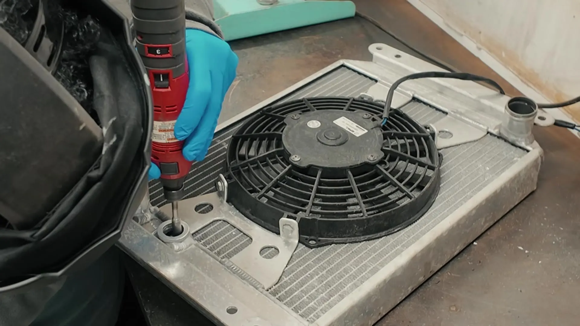 The radiator out on the bench, working the fan switch boss