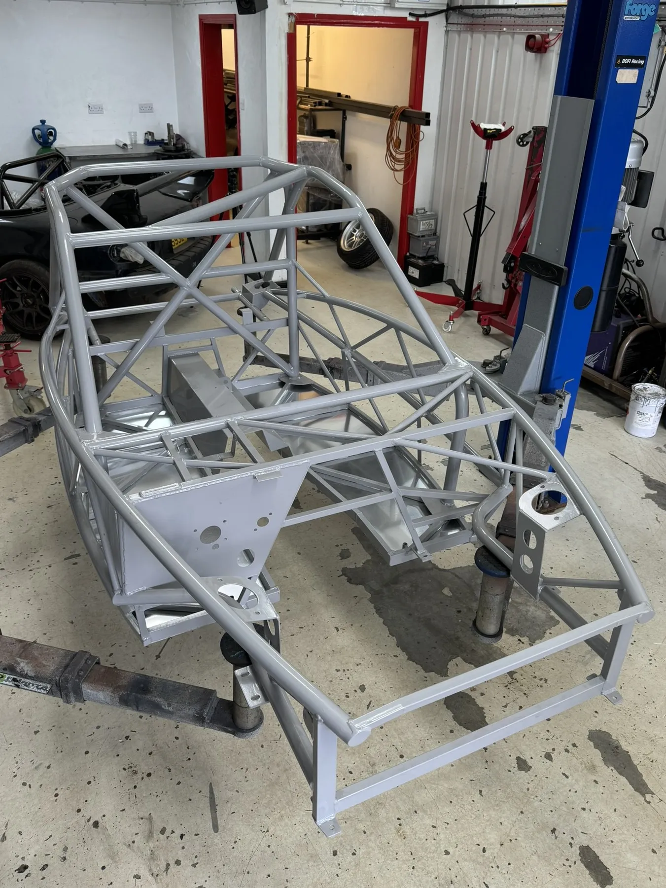 The bare grey MEV chassis on the ramp, floor pans in