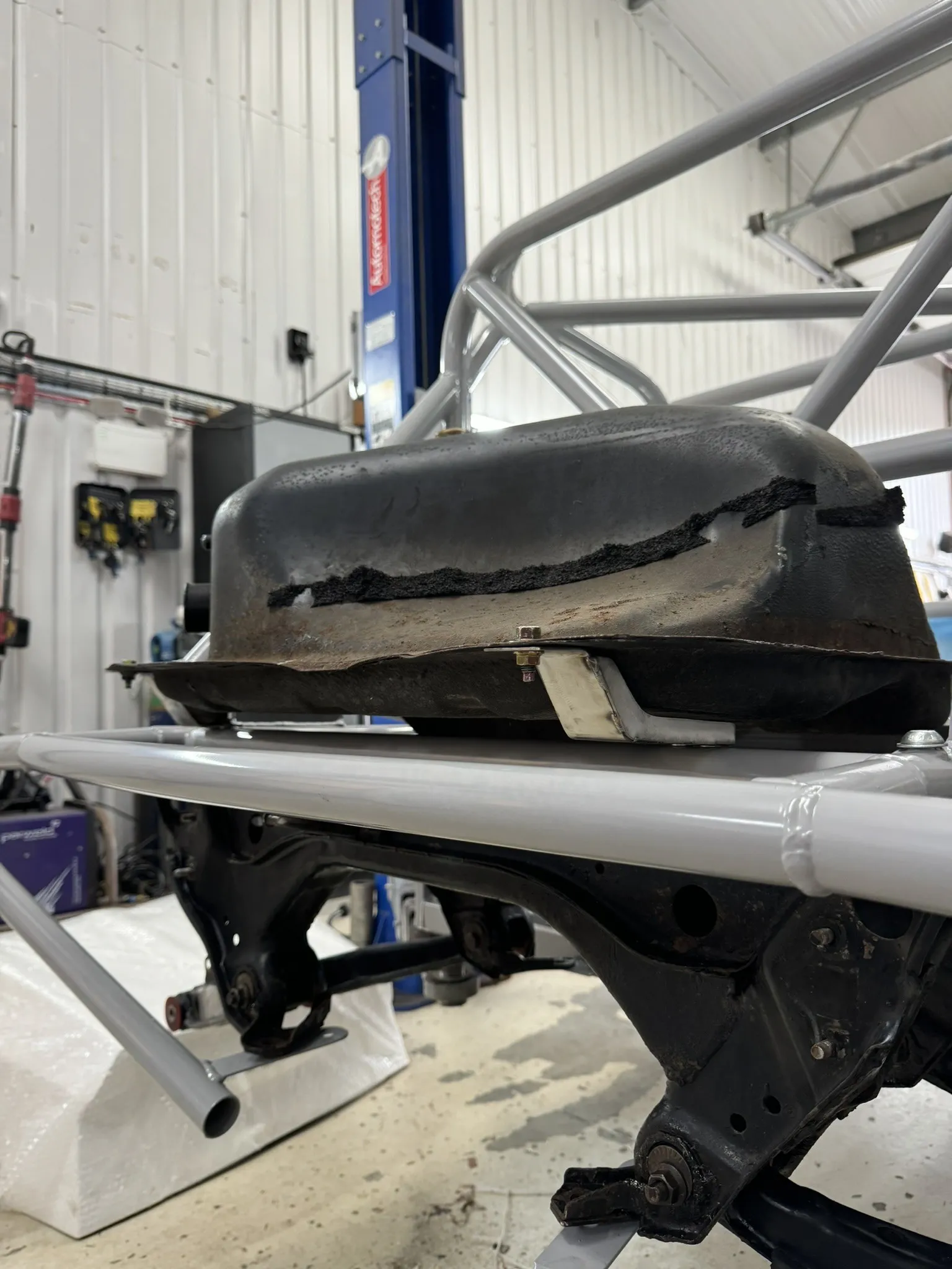 The fuel tank sitting on roughed out steel brackets in the rear of the chassis