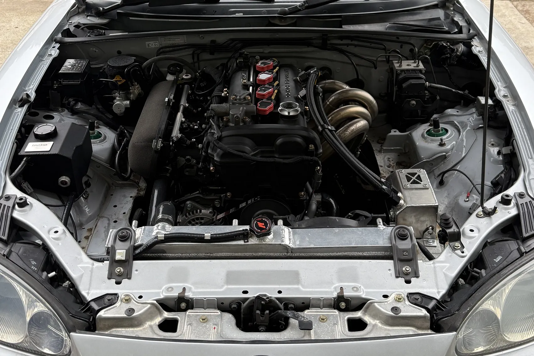Oliver's silver Mk2.5 with the bonnet up, the rebuilt 1.8 VVT in the bay with its loom, coils and stainless manifold in view.