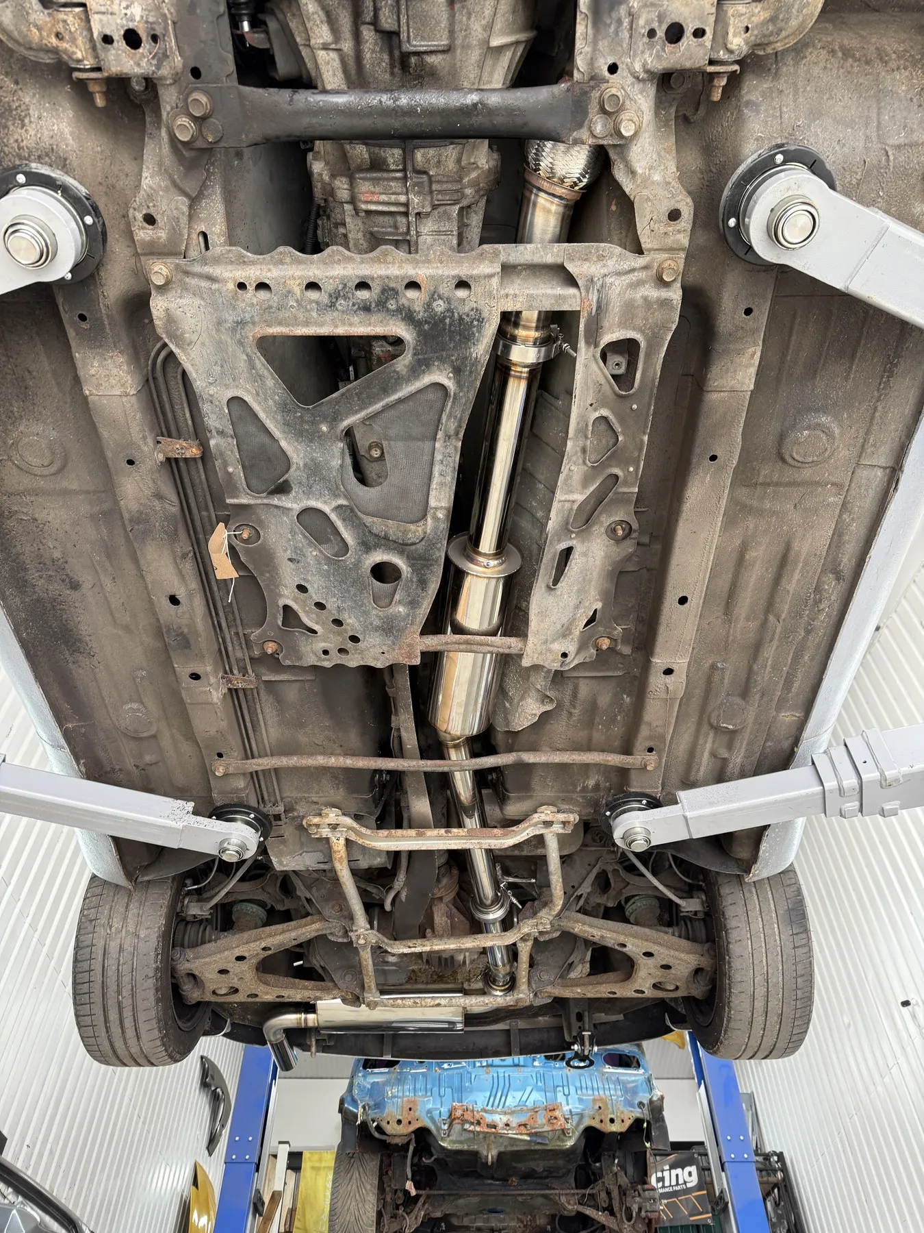 The full 2.5 inch stainless system fitted, seen from underneath the car on the ramp, running the length of the floor to the rear silencer