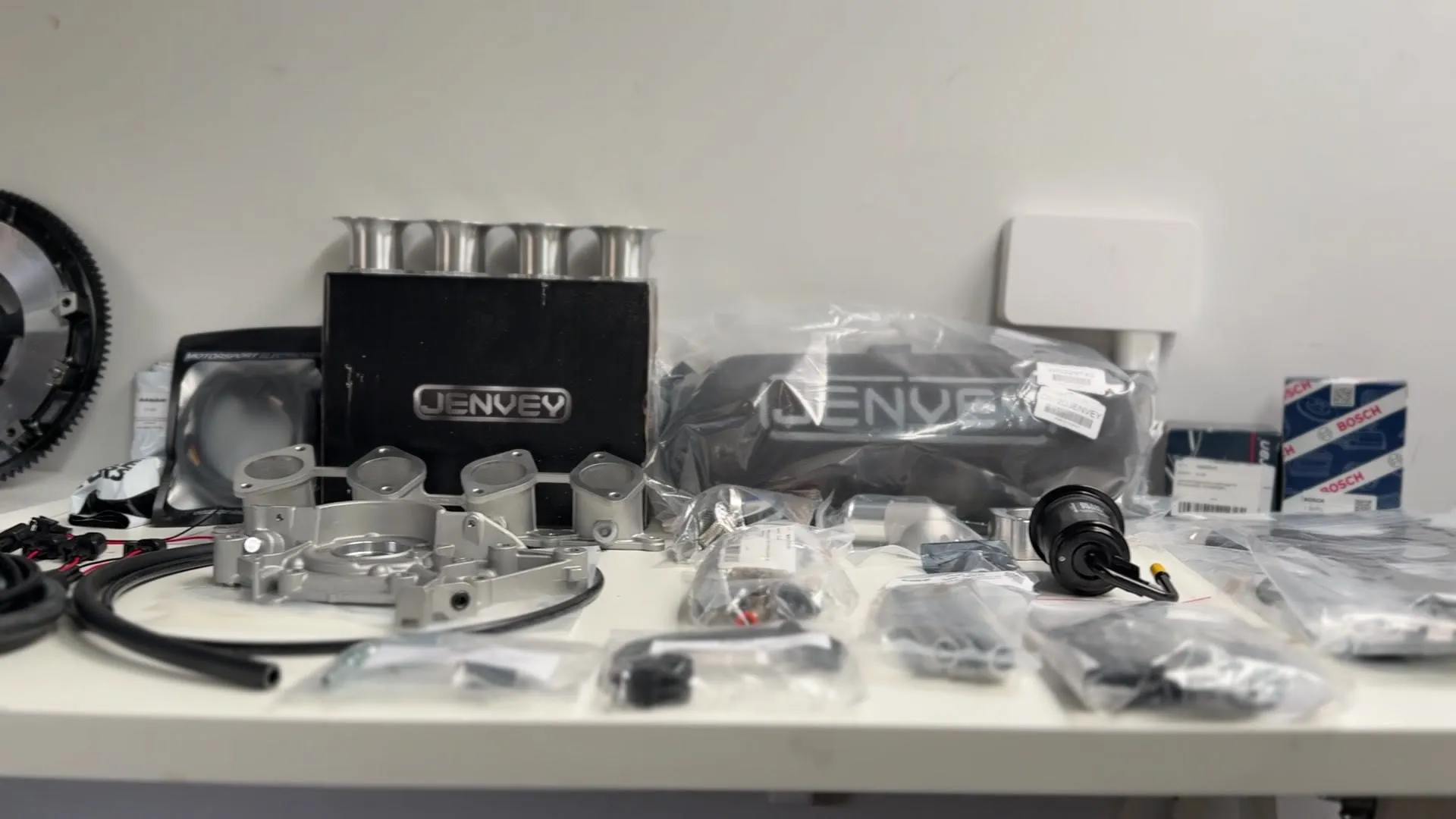 The parts package laid out on the bench, Jenvey throttle bodies and airbox, inlet manifold, lightweight flywheel, ECU and injectors