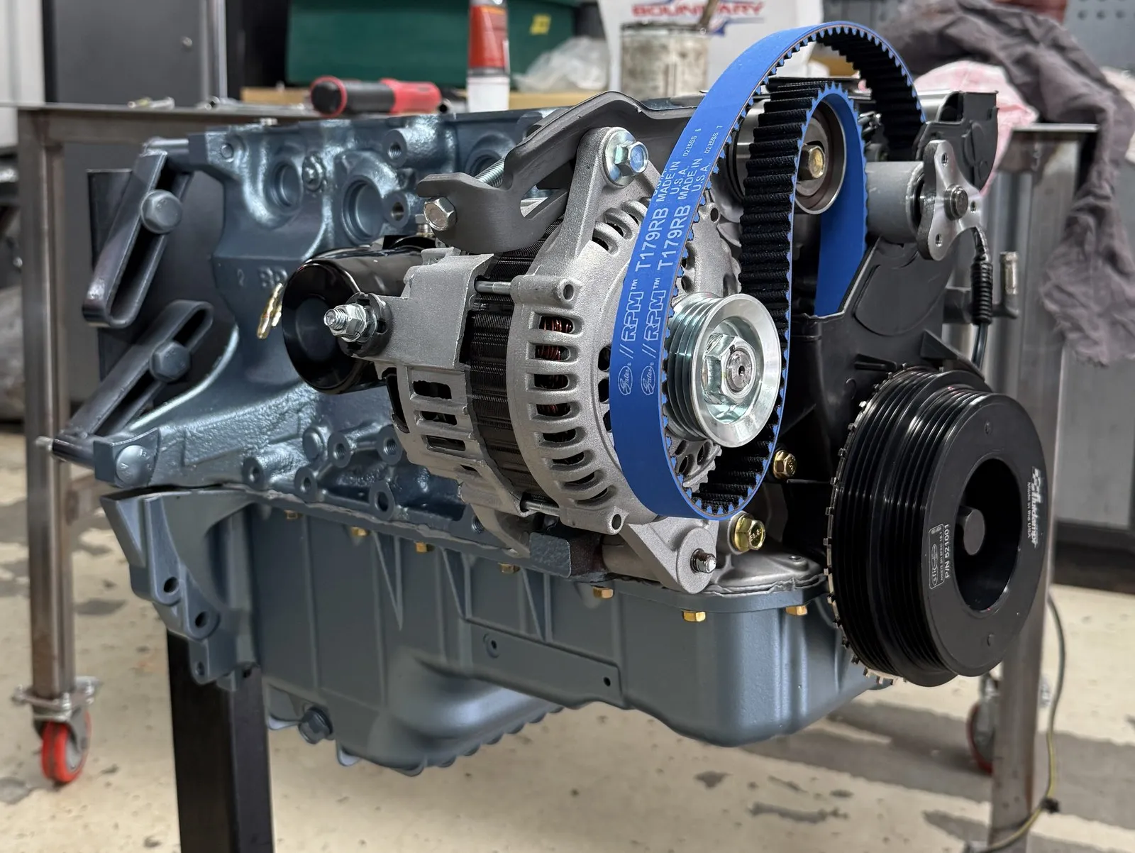 The painted short block on a stand in the workshop, new cambelt and pulleys fitted