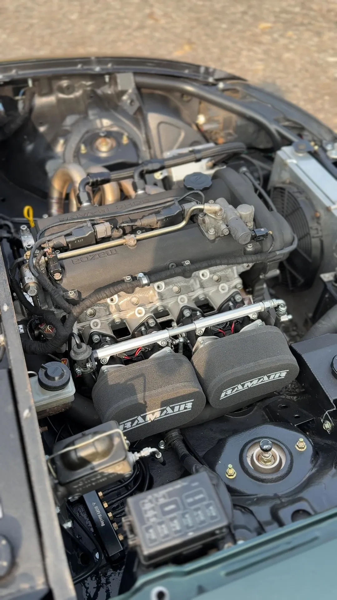 The finished engine bay looking down, throttle bodies with their filters on, manifold coloured from heat and everything clipped up