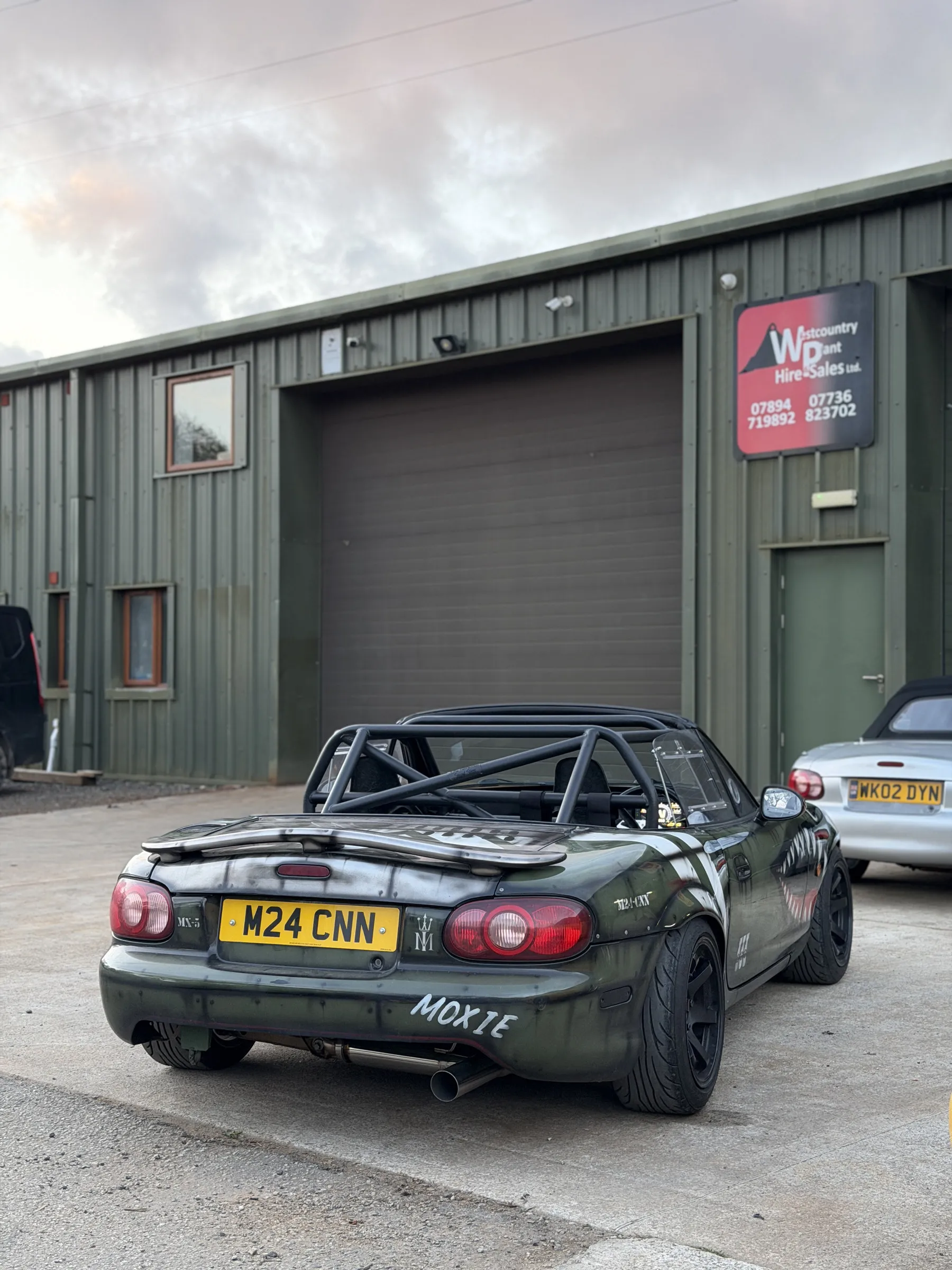 The rear of the car with the hard top on, MOXIE lettered across the rear quarter