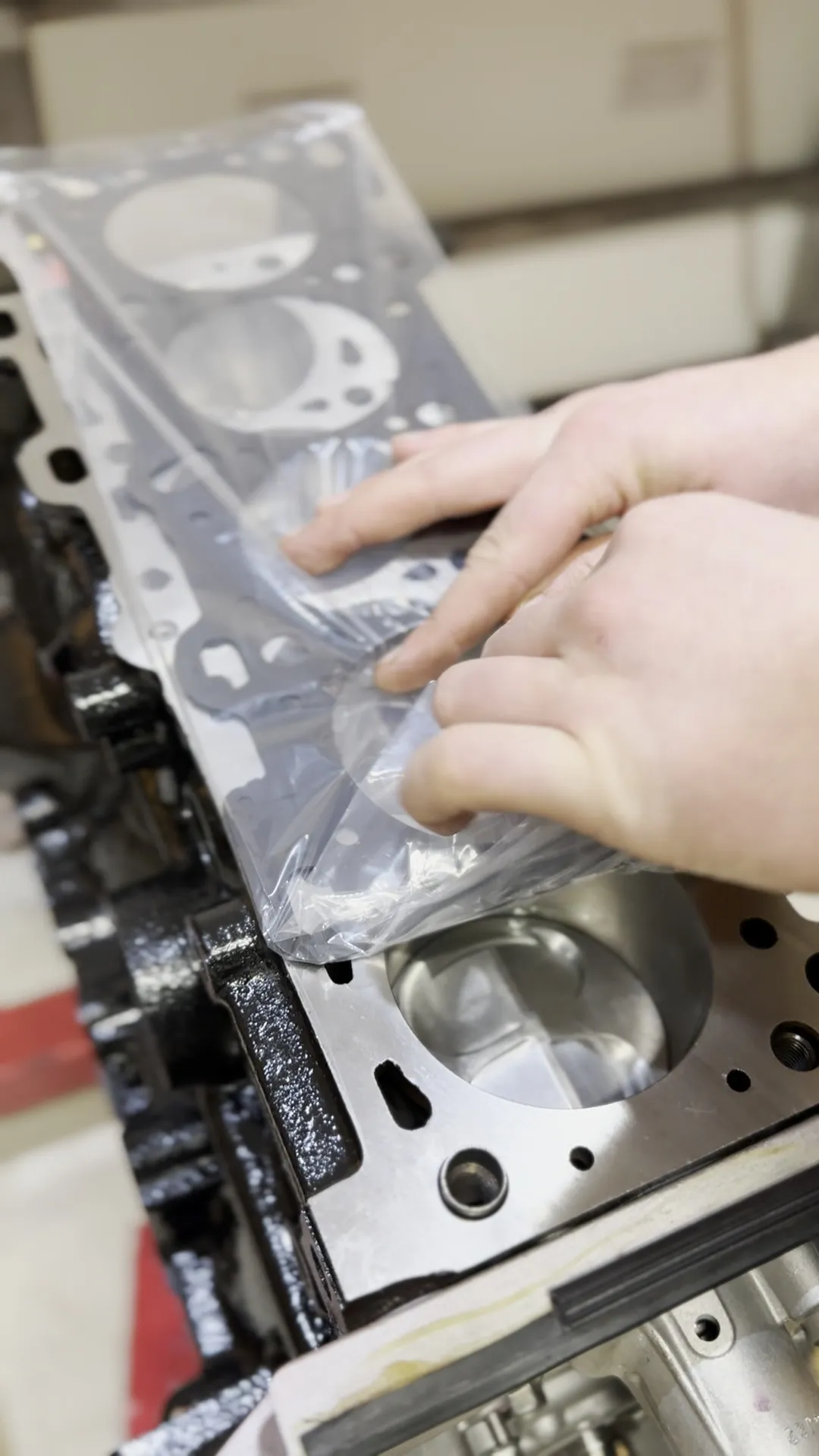 The head gasket held up over the block before the head goes back on
