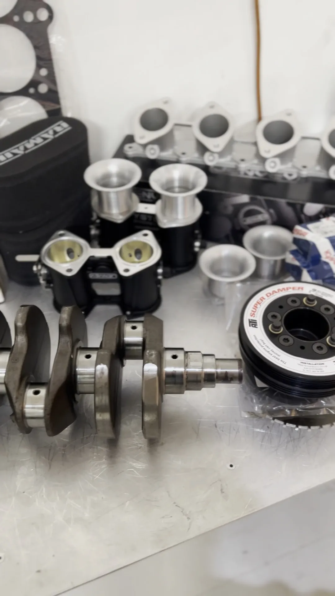The crank, pistons, bearings and boxed parts laid out on the bench before assembly