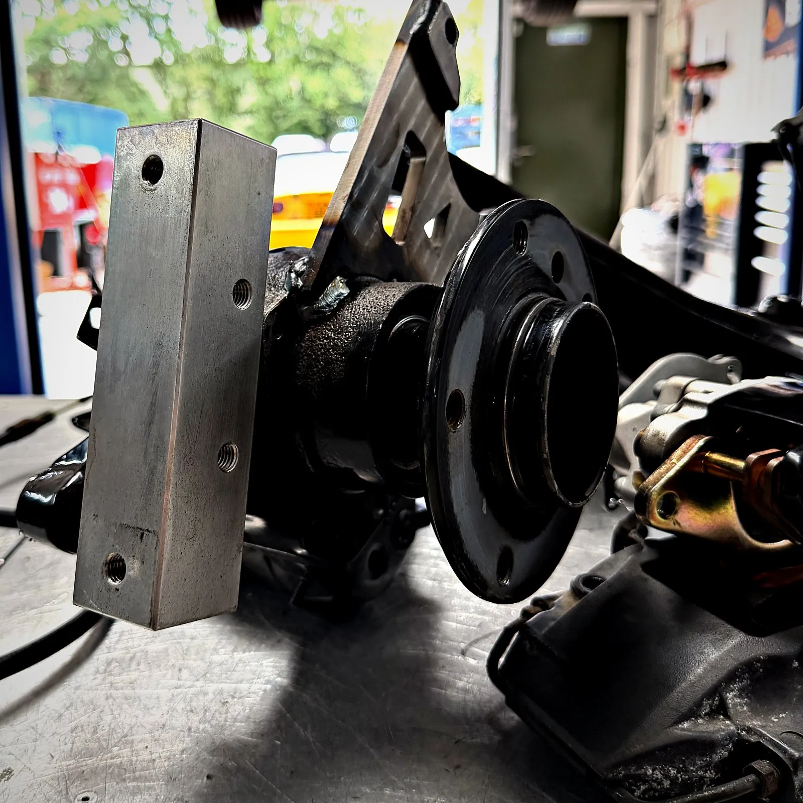 A machined aluminium caliper block bolted to the rear hub carrier, before the disc goes on