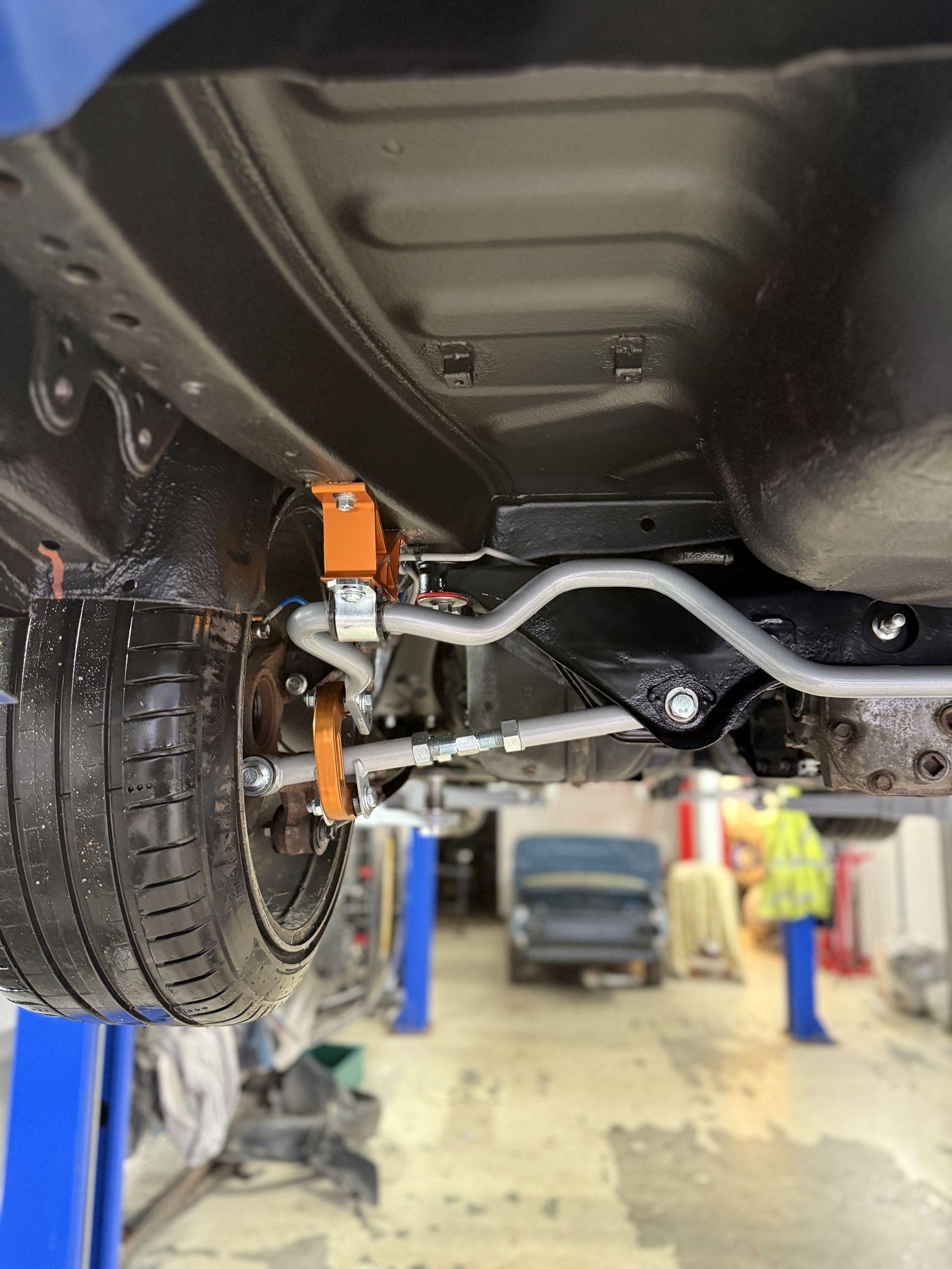 A freshly restored Subaru Impreza underbody on the ramp, new anti-roll bar and anodised drop links